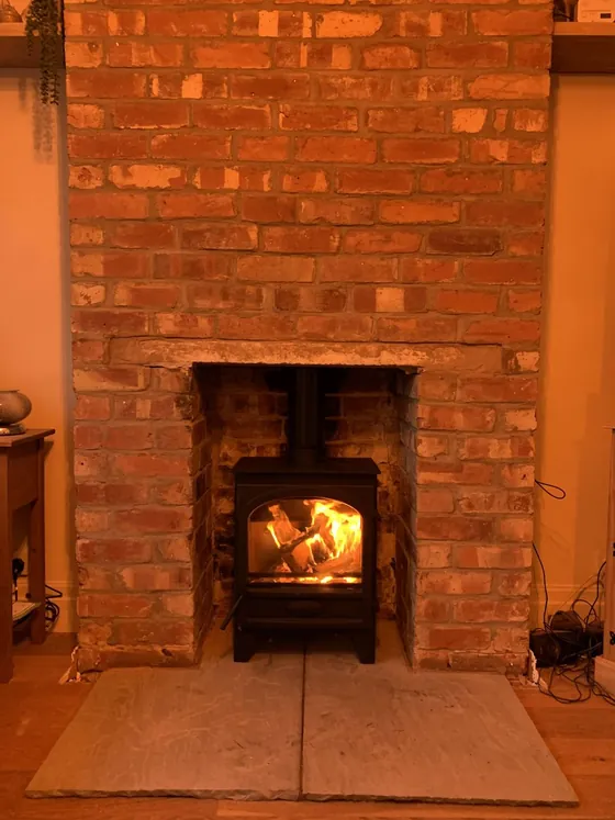 Open fire in a warm brick fireplace with a stone hearth