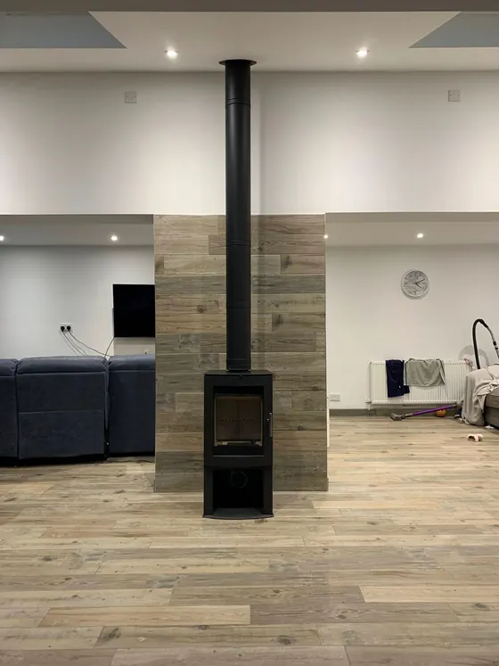 Black wood burner in an open-plan living space with wood flooring