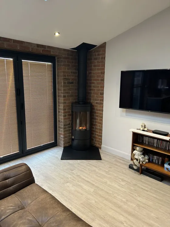 Corner wood burner installation with black flue pipe
