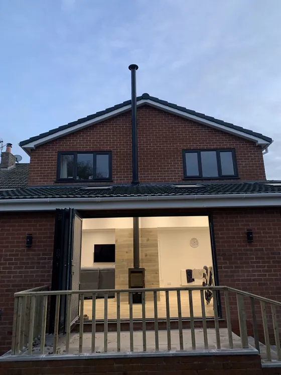 New wood burner install viewed from a garden through bifold doors