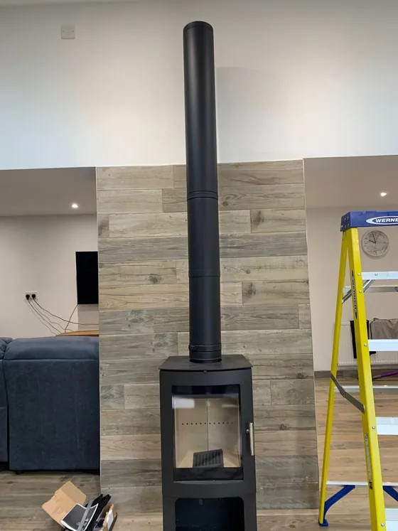 Stove installation in progress with the flue being fitted