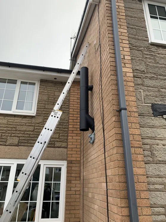 Twin-wall insulated flue system fitted externally up a brick house wall