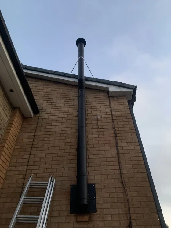 Insulated flue installed up the exterior of a house