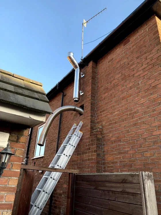 Chimney and flue work carried out from a ladder on a brick house